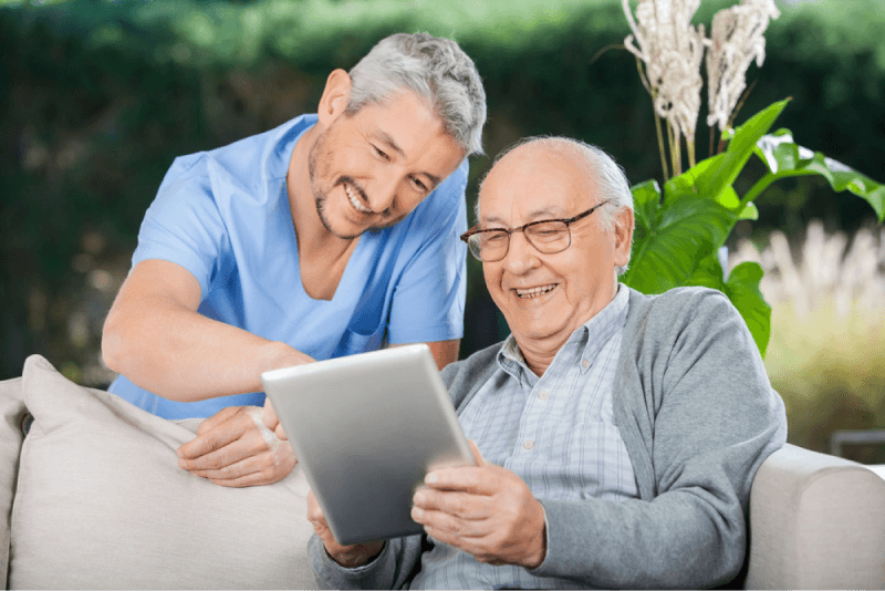 homecare nurse and elderly man using a computer